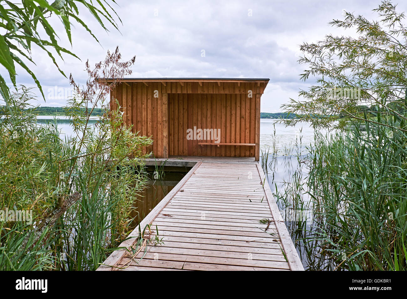 Birdwatch abri avec bord à revêtement en bois, à l'extrémité d'une jetée en bois d'aller dans l'eau d'un lac à Birkeroed, Banque D'Images