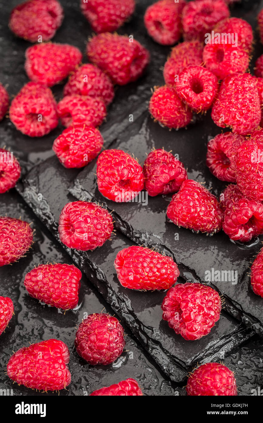 Les framboises rouges frais sur un fond d'ardoise Banque D'Images