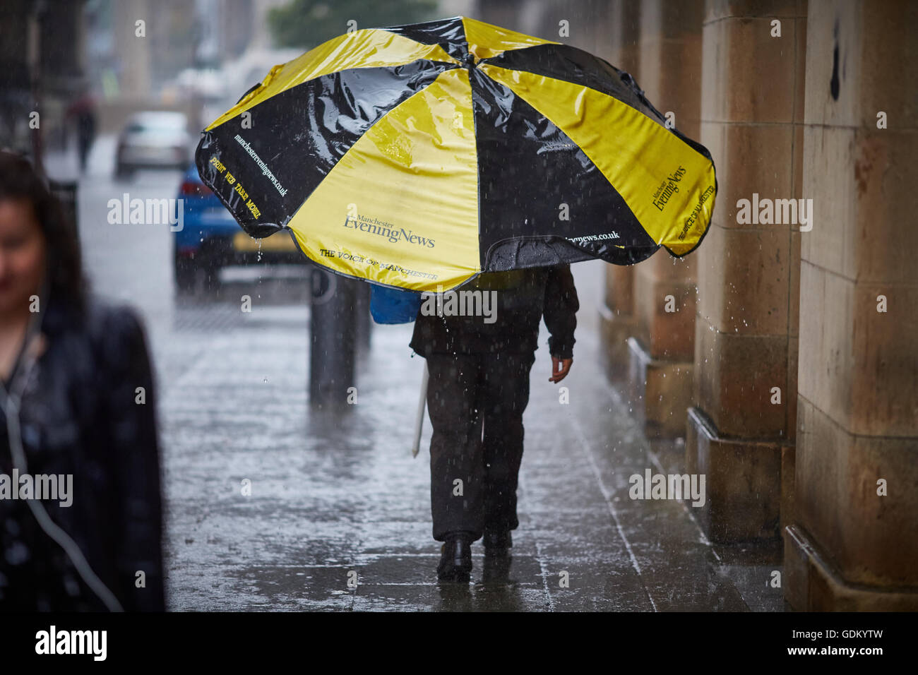 De fortes pluies dans le centre-ville de Manchester pleuvent pour trempage humide imbibé de parapluie en marbre pavement spay mi Banque D'Images