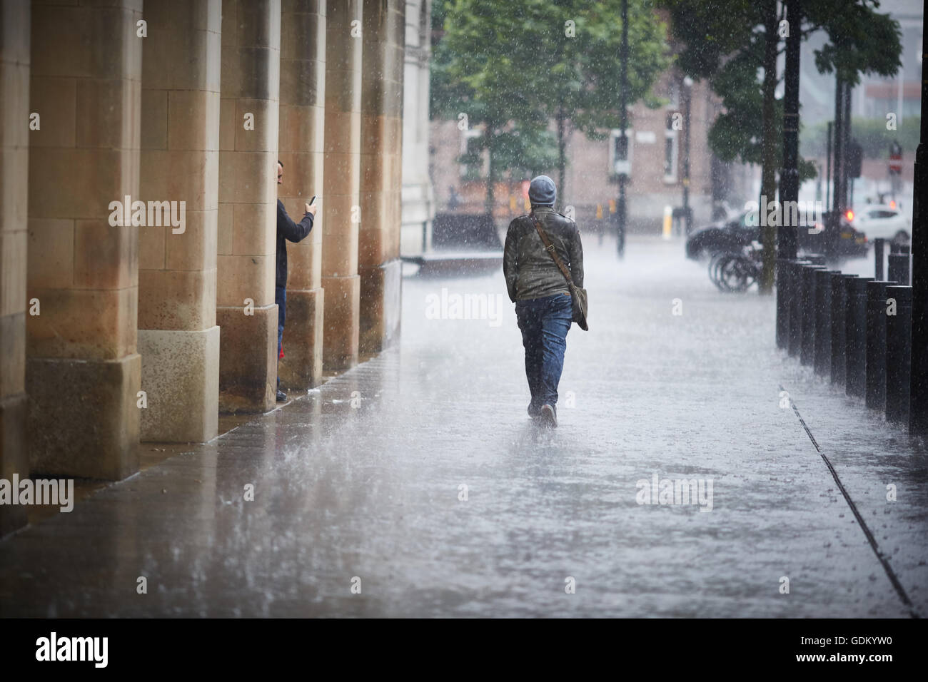 De fortes pluies dans le centre-ville de Manchester pleuvent pour trempage humide imbibé de parapluie en marbre pavement spay mi Banque D'Images
