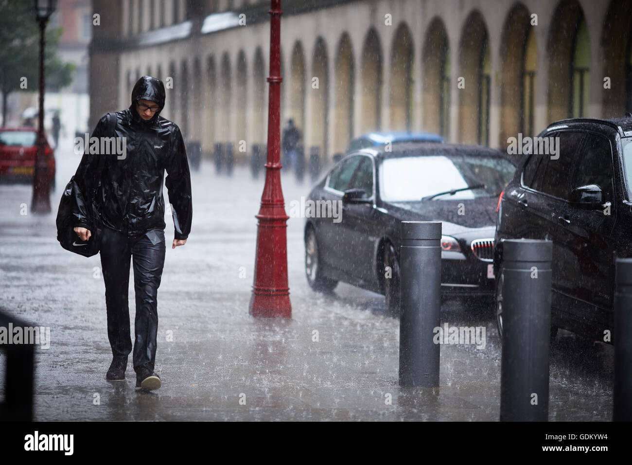 De fortes pluies dans le centre-ville de Manchester pleuvent pour trempage humide imbibé de parapluie en marbre pavement spay mi Banque D'Images