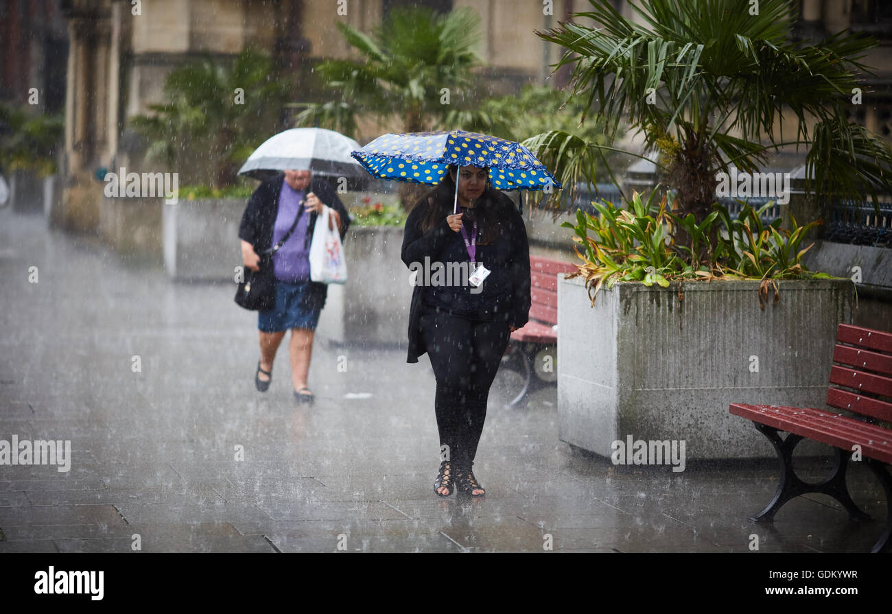 De fortes pluies dans le centre-ville de Manchester pleuvent pluie trempé par trempage humide pour rebondir parapluie de marbre pavement Banque D'Images