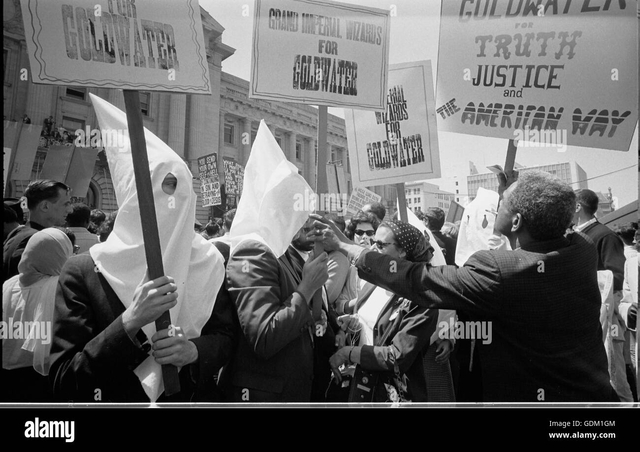 Ku Klux Klan membres appuyant la campagne de Barry Goldwater pour l'investiture présidentielle lors de la Convention Nationale Républicaine, San Francisco, Californie, en tant qu'africain-américain homme pousse signe en retour. Warren K. Leffler, photographe. Banque D'Images
