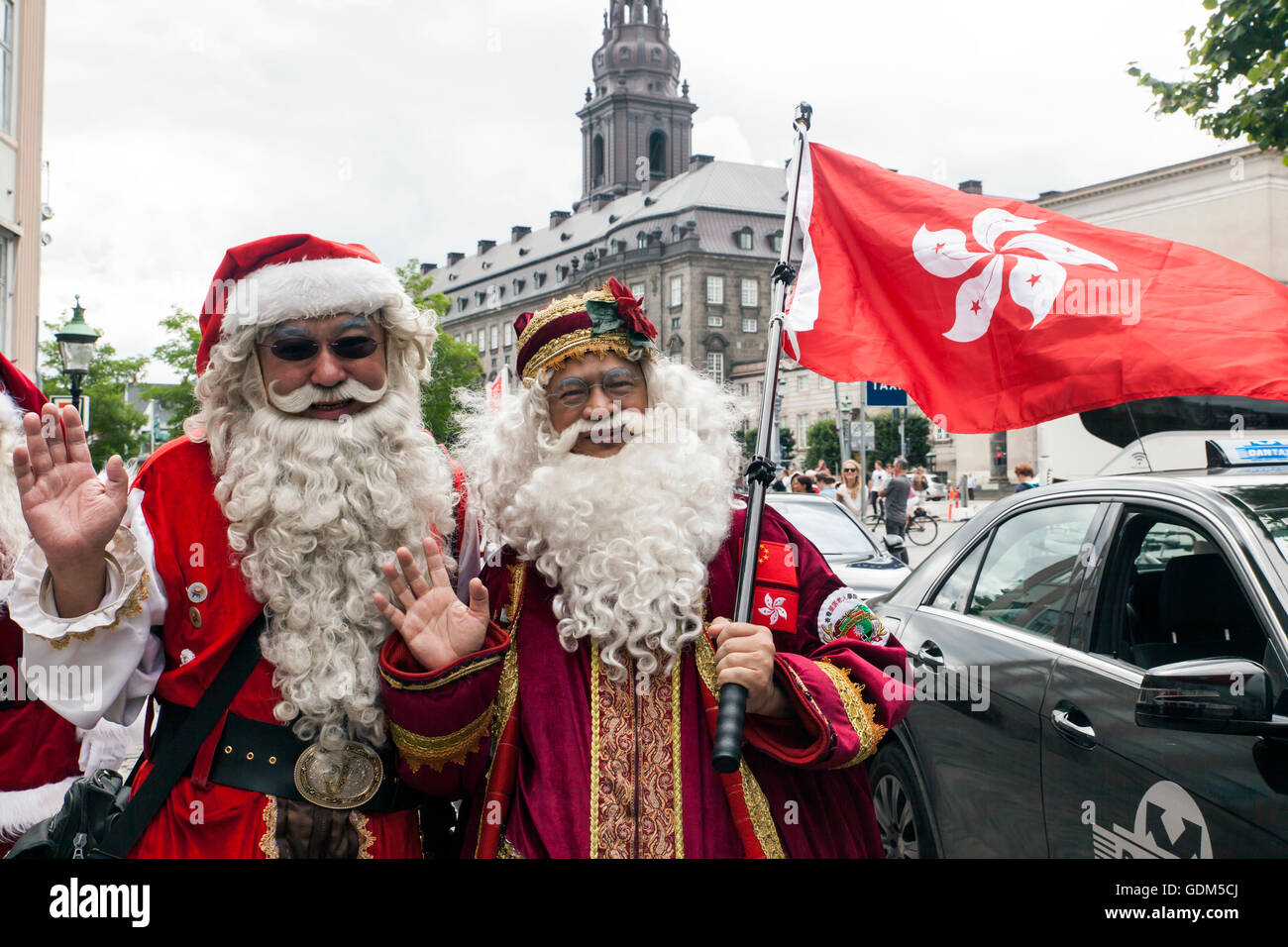 Copenhague, Danemark - Juillet 18, 2016 : le Père Noël à partir de Hong Kong - Santa Jim (L) et Santa Johnny (R), tous deux de l'École Santa Hong Kong - participe à l'Organisation mondiale de Père Noël 2016 Congrès à Copenhague. Ici en photo lors de leur tournée à travers la capitale danoise (arrière-plan, le Parlement, Christiansborg), qui a commencé à la statue de la Petite Sirène à l'Langelinie promenade du port et ensuite continué par bateau à la ville où ils se défilent dans la principale zone commerçante de l'Hôtel de Ville. Le congrès a eu lieu depuis 1957. Credit : OJPHOTOS/Alamy Live News Banque D'Images