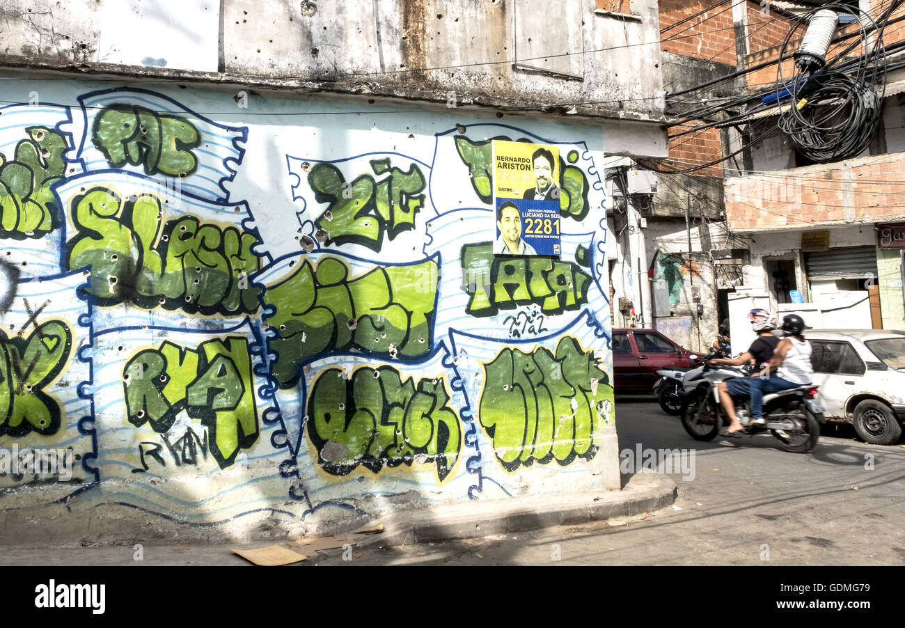 Rio de Janeiro, Brésil. 16 juillet, 2016. Peintures Graffiti sur un mur fortifiés avec trous de balle dans la guerre de la drogue entre la police et les Comando Vermelho (commando rouge allumé.) dans la favela Complexo do Alemão à Rio de Janeiro, Brésil, 16 juillet 2016. Le Complexo est une grande favela de Rio de Janeiro, composé de 25 villes. Photo : Peter Bauza/dpa/Alamy Live News Banque D'Images