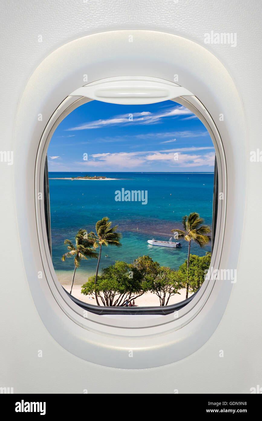 Fenêtre d'un avion de l'intérieur, vue sur une plage tropicale et la mer Banque D'Images