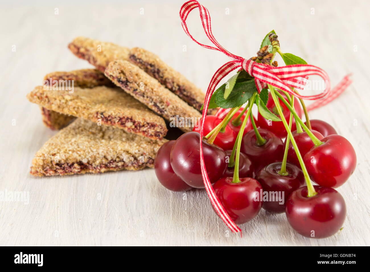 Partie intégrante des cookies avec des cerises sur une table en bois Banque D'Images