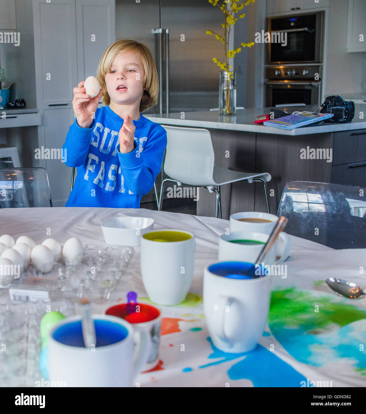 Garçon dans la cuisine décorer les œufs de Pâques Banque D'Images