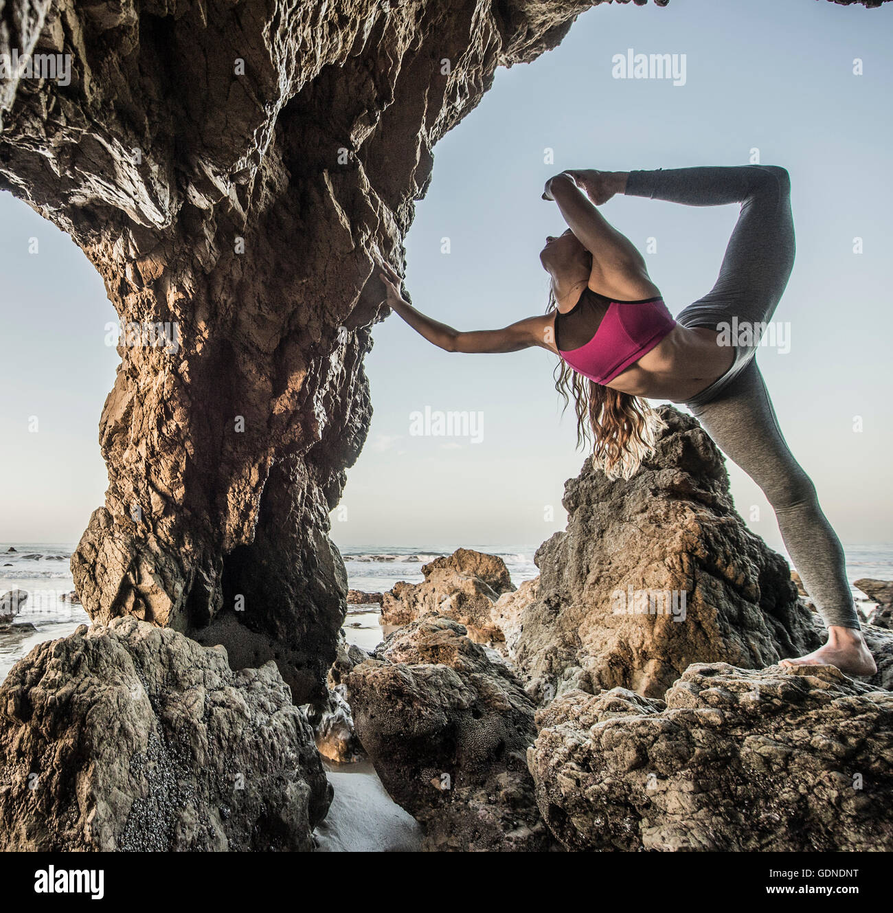 Jeune danseuse en équilibre sur une jambe en mer agitée, Los Angeles, Californie, USA Banque D'Images