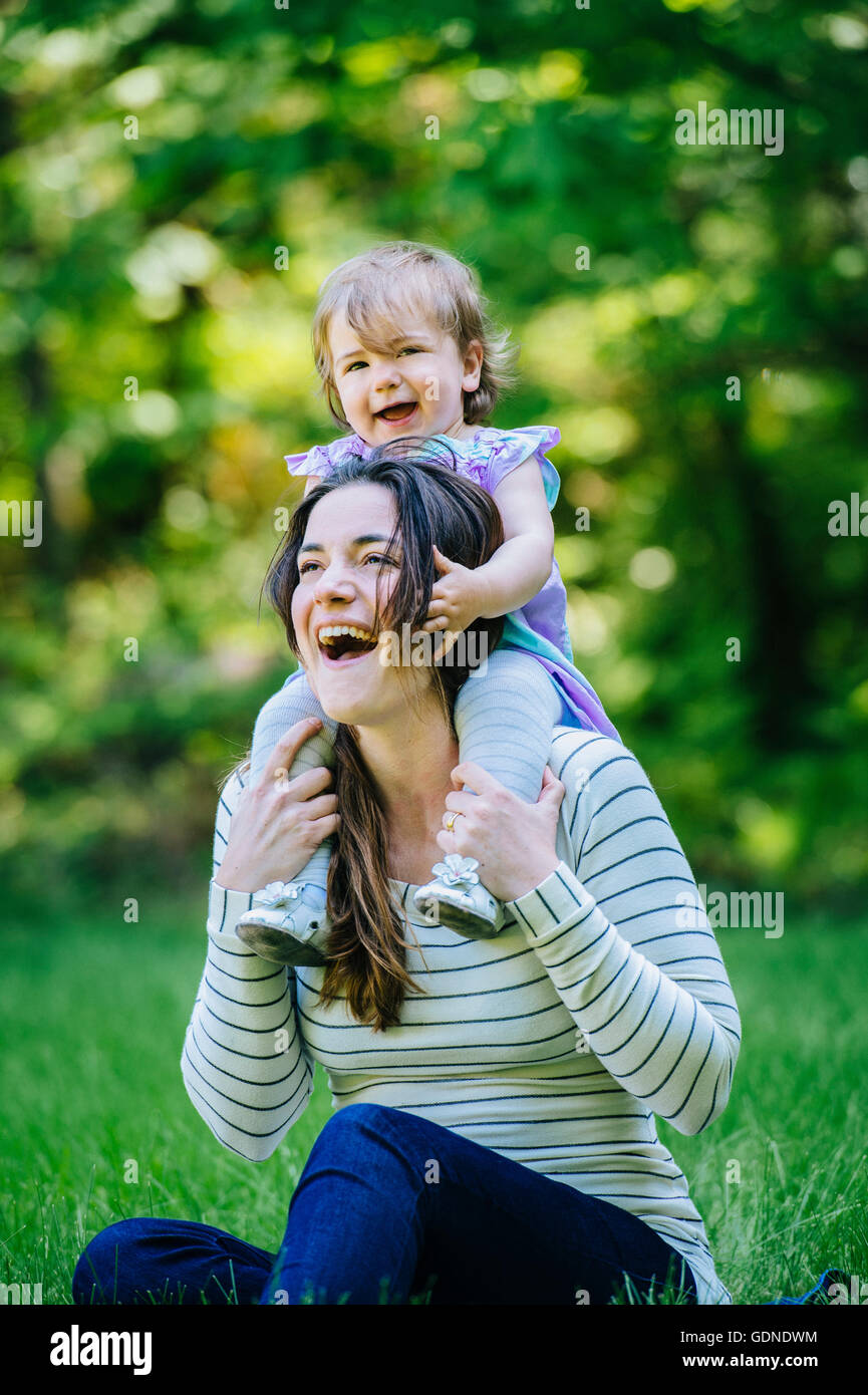 Female toddler obtenir une épaule ride de la mère in park Banque D'Images