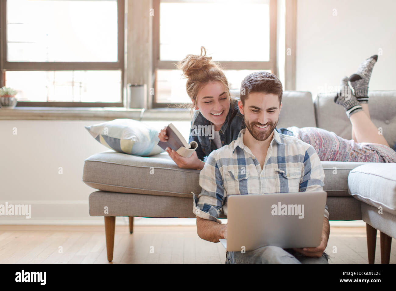 Young couple relaxing at home, looking at laptop Banque D'Images