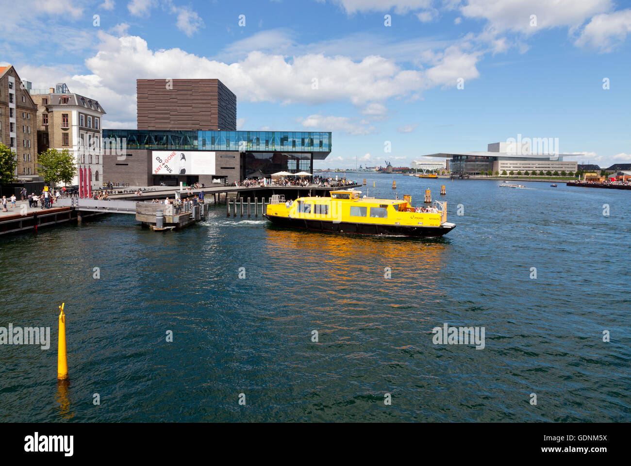 Un port jaune autobus arrive au Royal Playhouse dans le port de Copenhague. La Royal Opera House en face plus loin. Banque D'Images