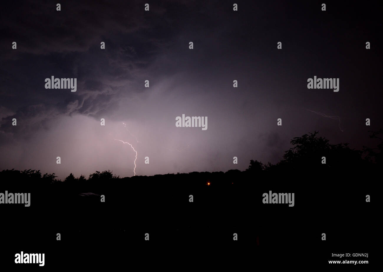 La foudre dans la nuit. Ciel noir Envoyer clignote en bas dans la forêt. Banque D'Images