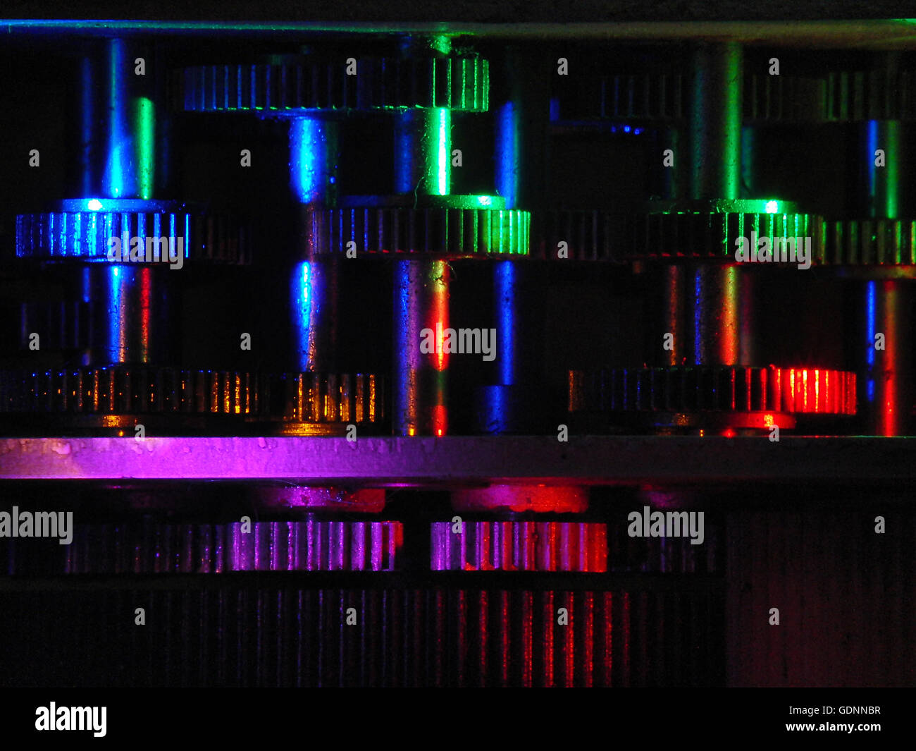 Boîte de vitesses avec des roues en métal vu en lumière colorée. Banque D'Images