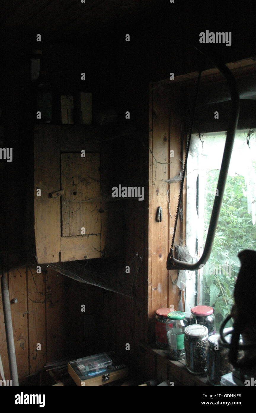 Vu de l'intérieur ancien atelier en lumière tamisée à partir d'une fenêtre sale. Banque D'Images