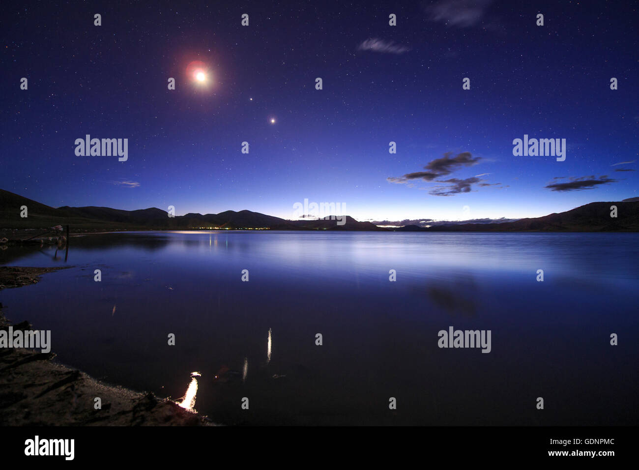 Conjonction de la lune, Jupiter et Vénus s'affichent pendant l'crépuscule du soir au-dessus du beau lac Yamdrok au Tibet, en Chine. Banque D'Images