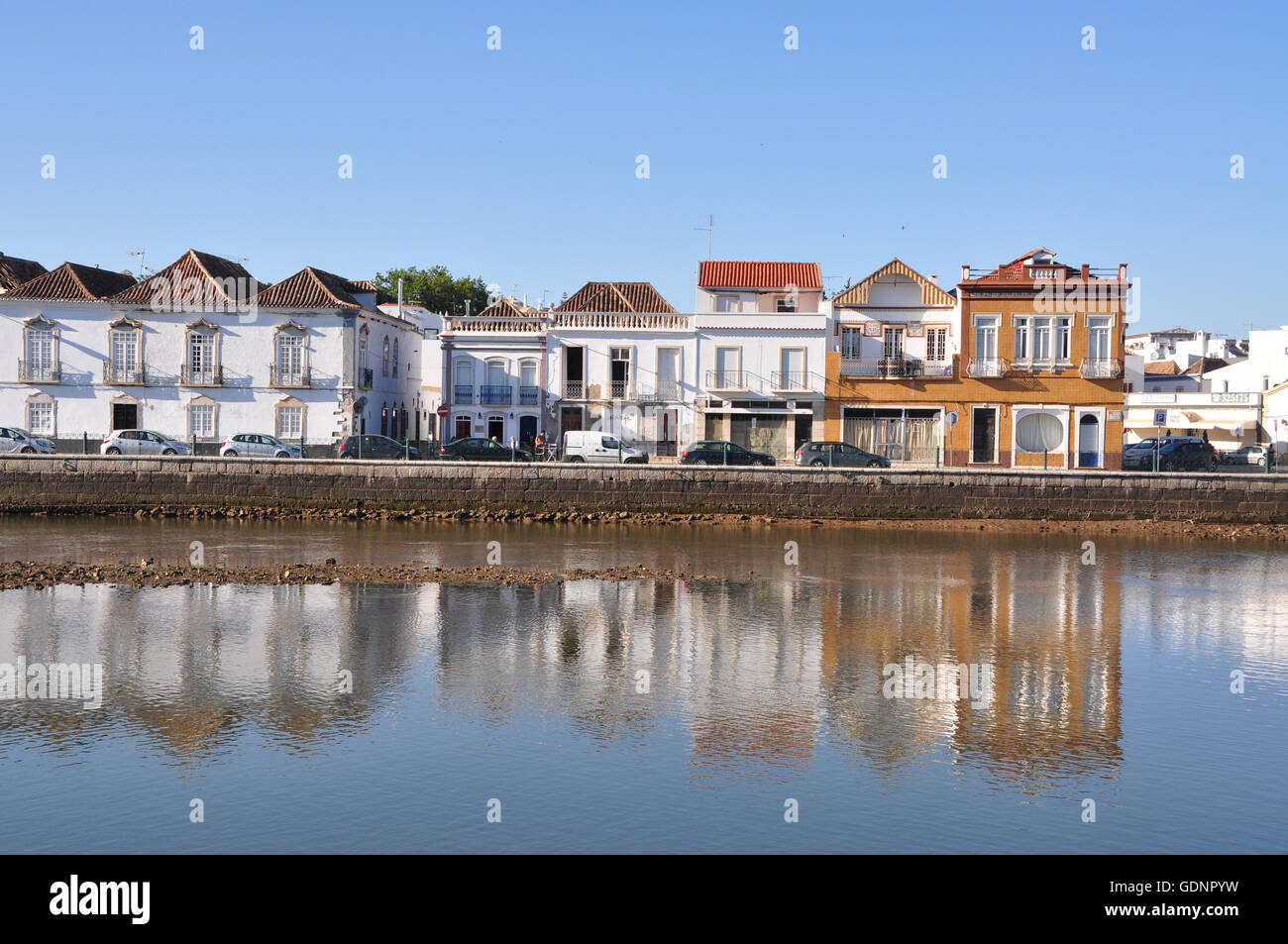 L'architecture portugaise waterfront reflétée sur l'eau sur l'après-midi chaud et ensoleillé avec un ciel bleu à Tavira, près de Faro en Algarve Région du Portugal. Banque D'Images