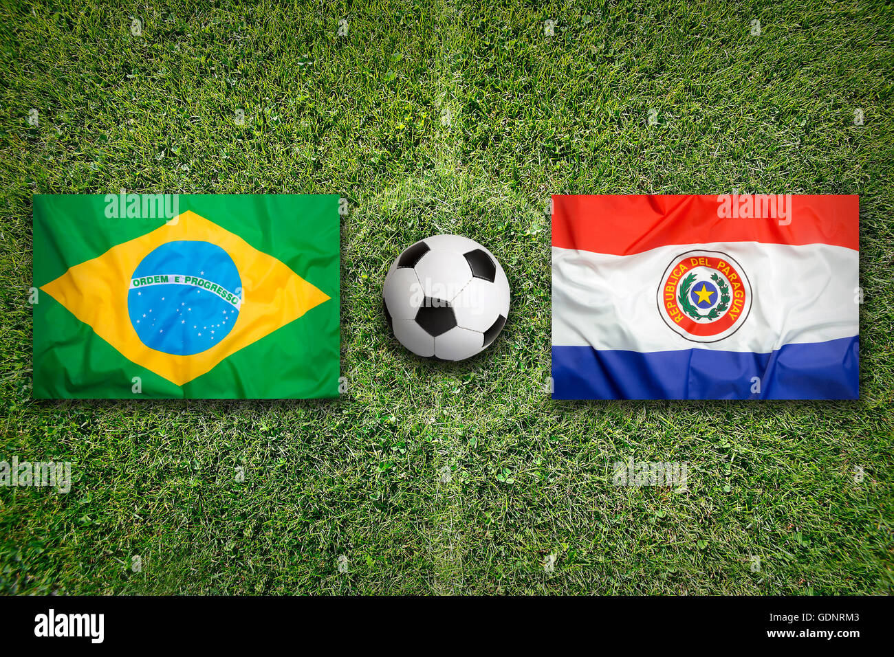 Brésil vs Paraguay les drapeaux sur le terrain de soccer vert Banque D'Images