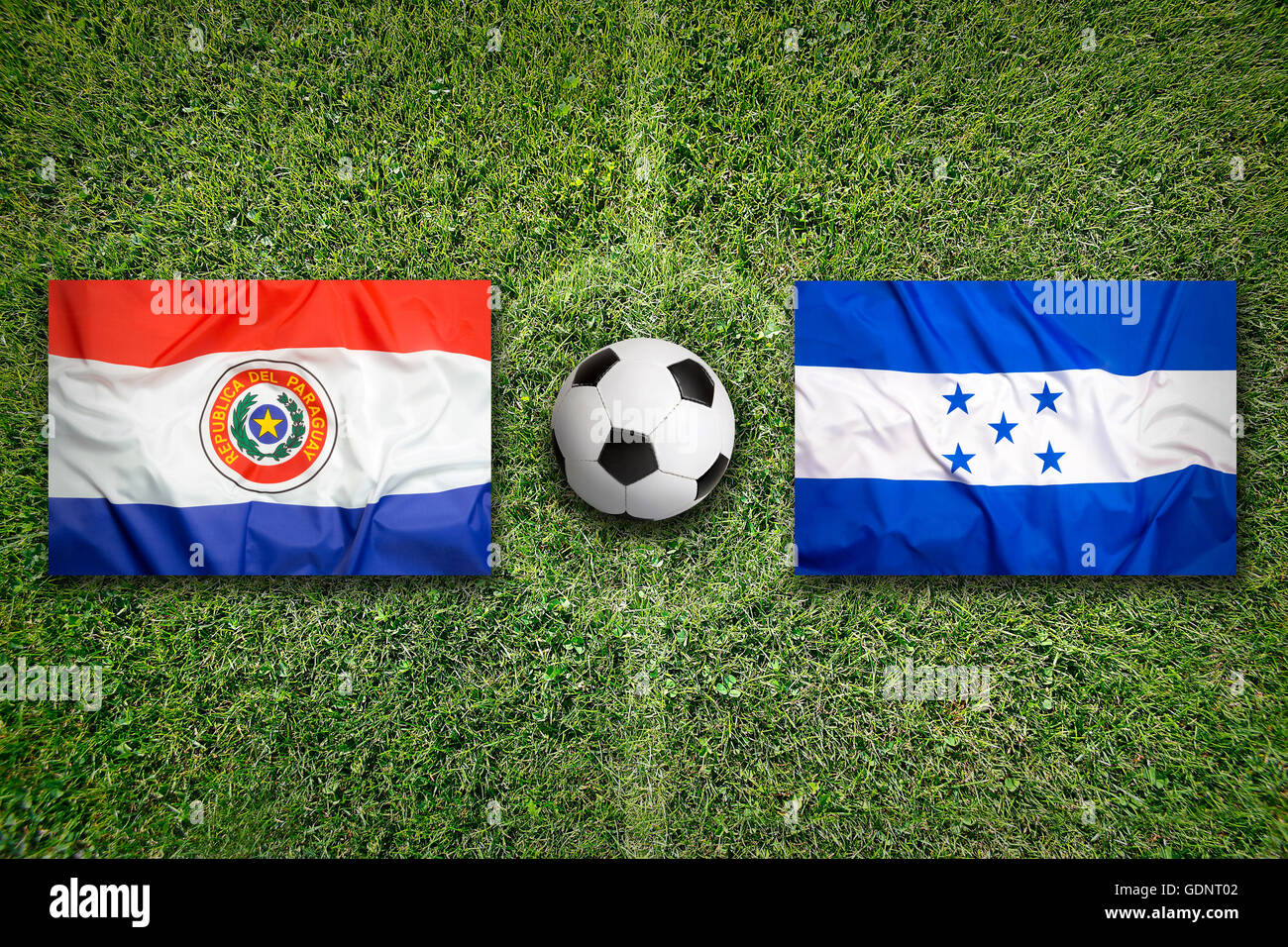 Paraguay vs Honduras les drapeaux sur le terrain de soccer vert Banque D'Images