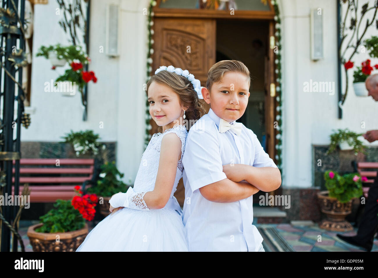 Première communion, frère et sœur en choisissant robe blanche de l'église  en arrière-plan Photo Stock - Alamy