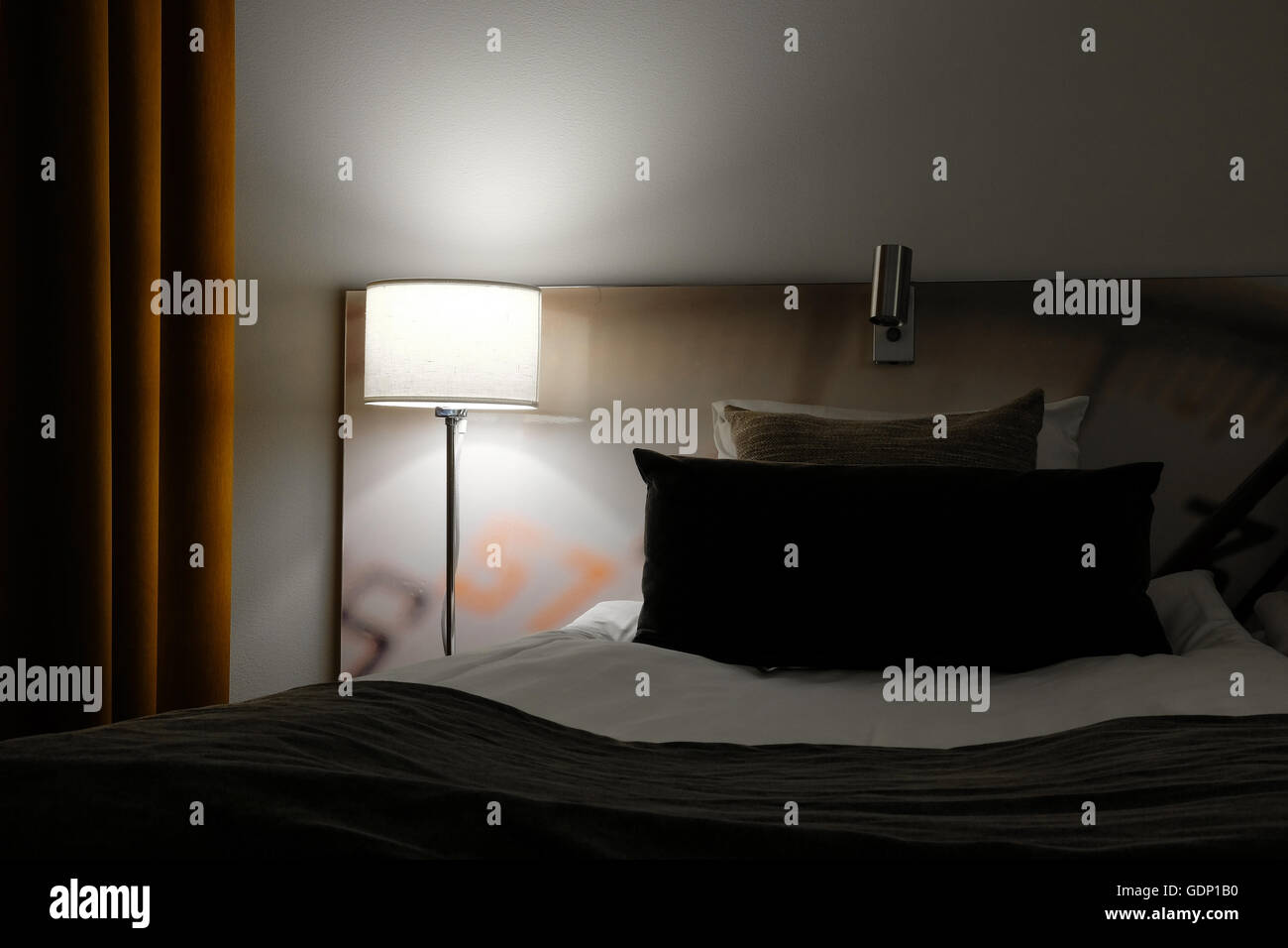 Chambre d'hôtel de nuit, que couvercle en une petite lampe à côté du lit Banque D'Images