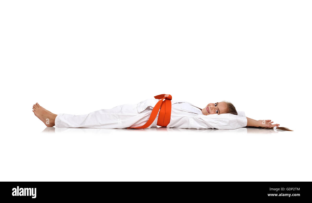 Peu de karate girl lying on the floor Banque D'Images