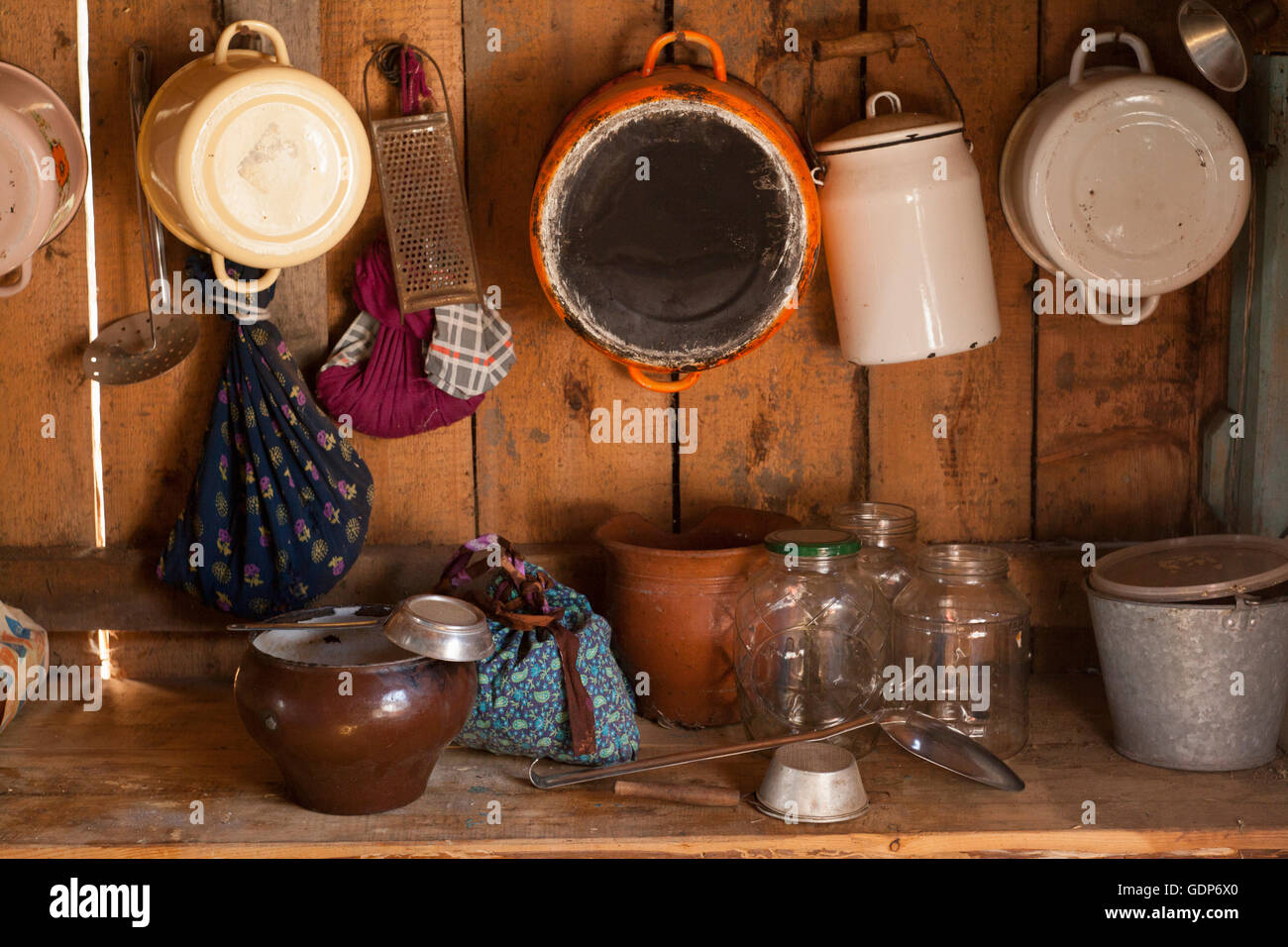 Cuisine en bois traditionnel avec casseroles, bols et ustensiles sur une étagère Banque D'Images