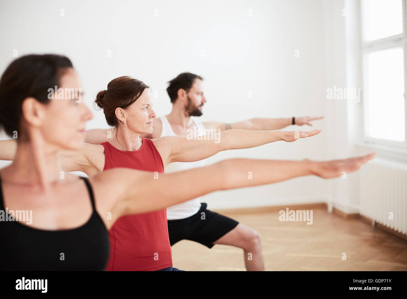 Les gens dans l'exercice studio arms open in yoga position Banque D'Images