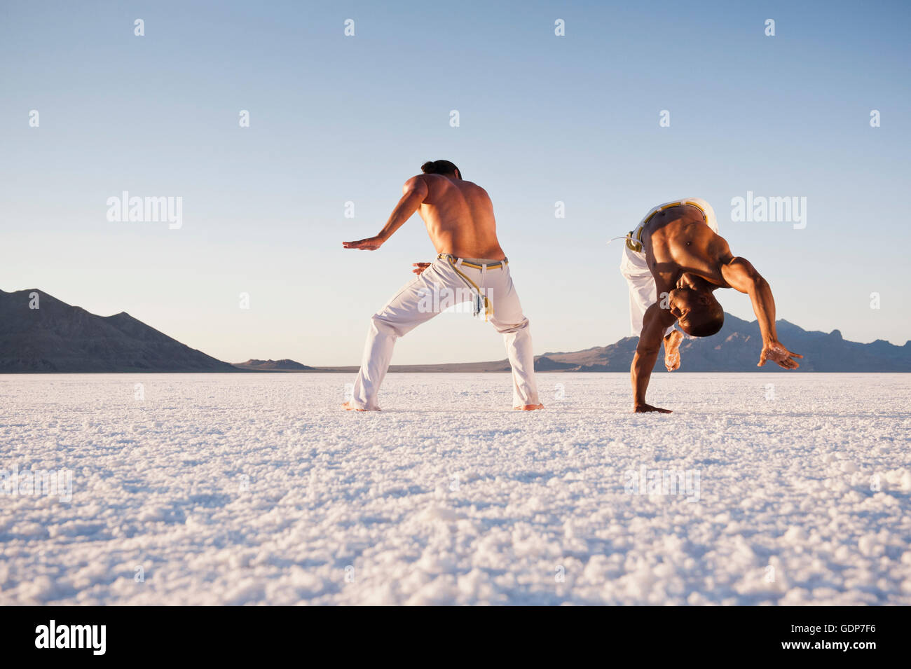 Niveau de la surface vue de deux hommes effectuant la capoeira sur Bonneville Salt Flats, Utah, USA Banque D'Images Niveau de la surface vue de deux hommes effectuant la capoeira sur Bonneville Salt Flats, Utah, USA Banque D'Images