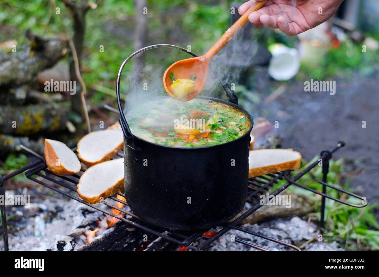 La cuisson de la soupe sur le feu sur le camping Banque D'Images