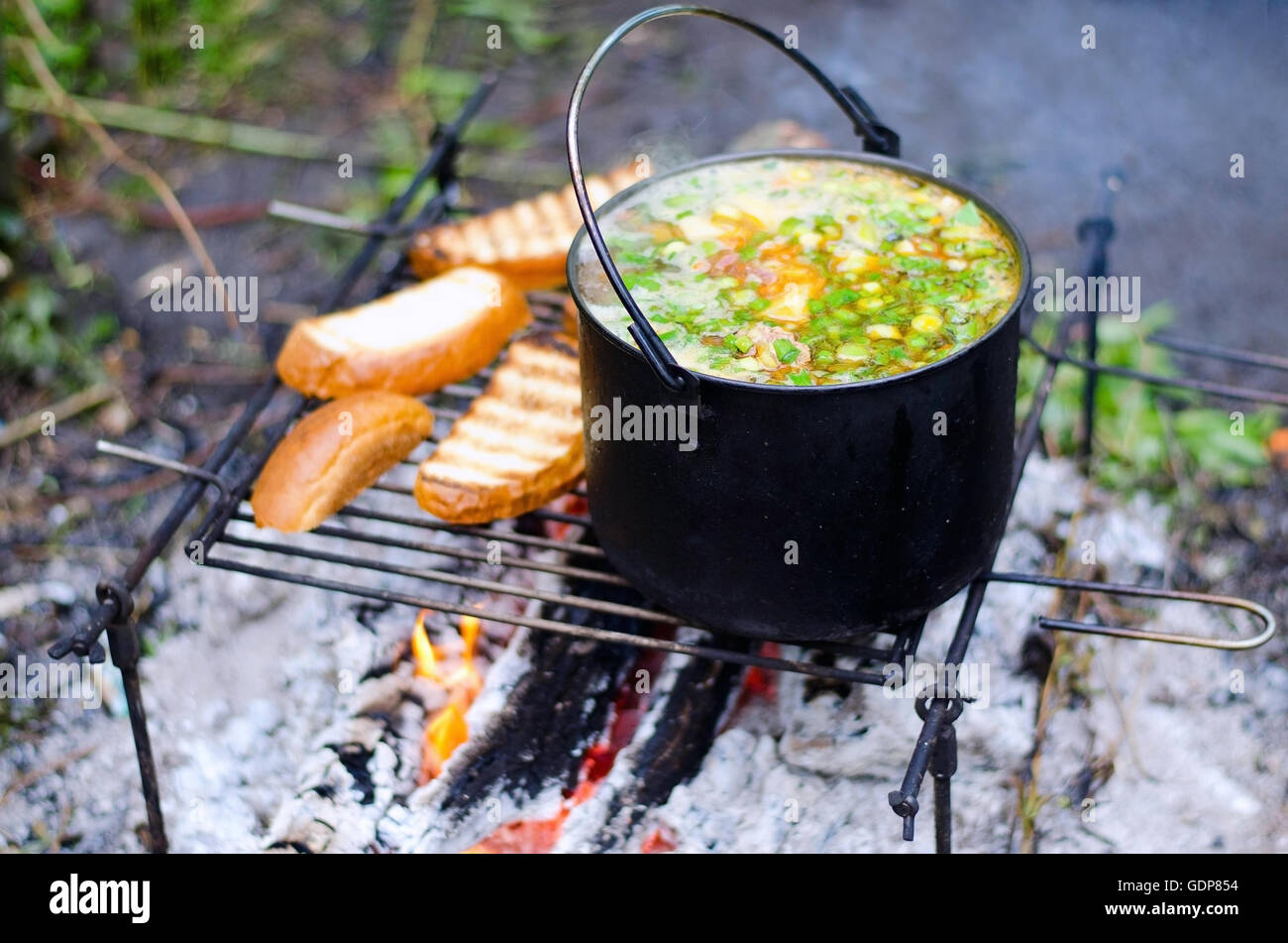 La cuisson de la soupe sur le feu sur le camping Banque D'Images