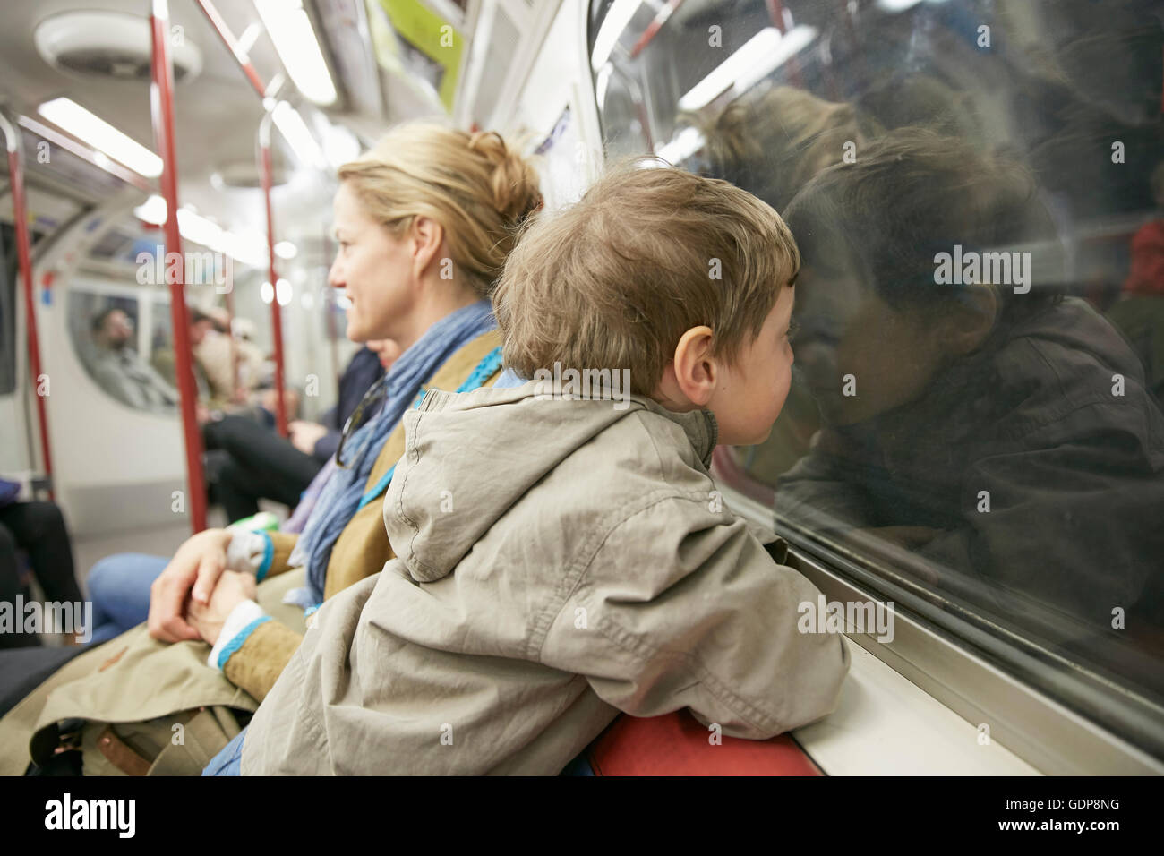 Garçon en train de tube de transport, face contre vitre Banque D'Images