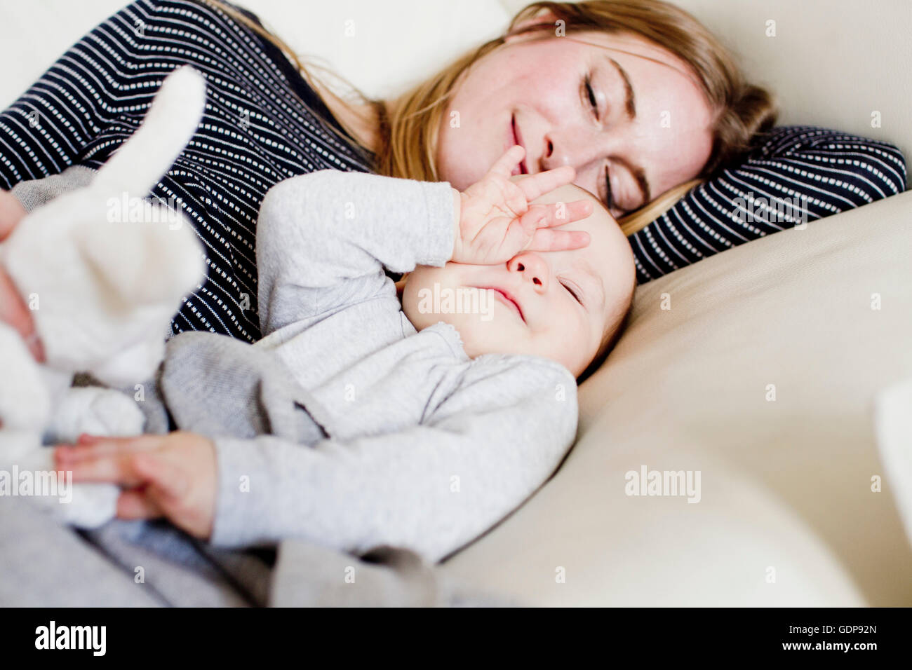 Mère et fille bébé fatigué de vous coucher sur un canapé Banque D'Images