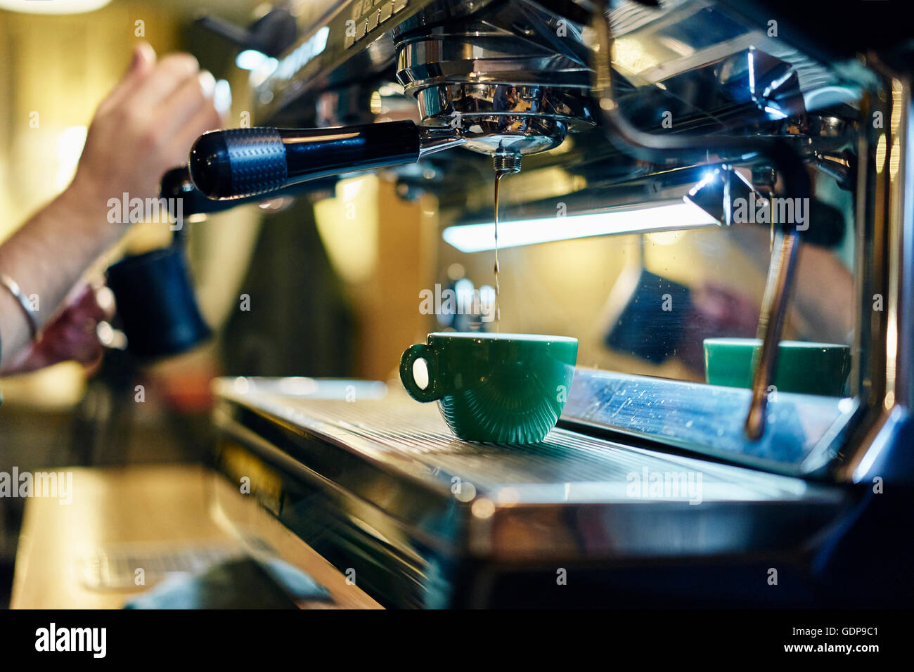 Mains de barista mâle chauffage pot à lait sur machine à café de coffee shop Banque D'Images