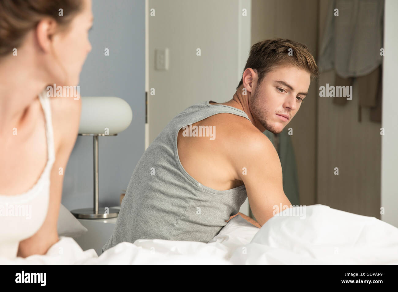 Jeune couple malheureux de se lever du lit Banque D'Images