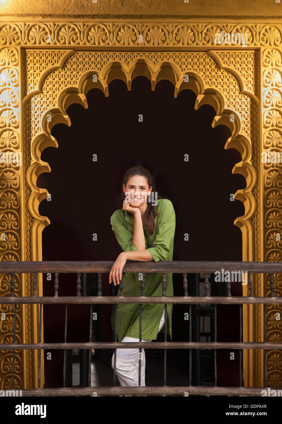 Femme en porte ouvragée à la caméra en souriant, Marrakech, Maroc Banque D'Images