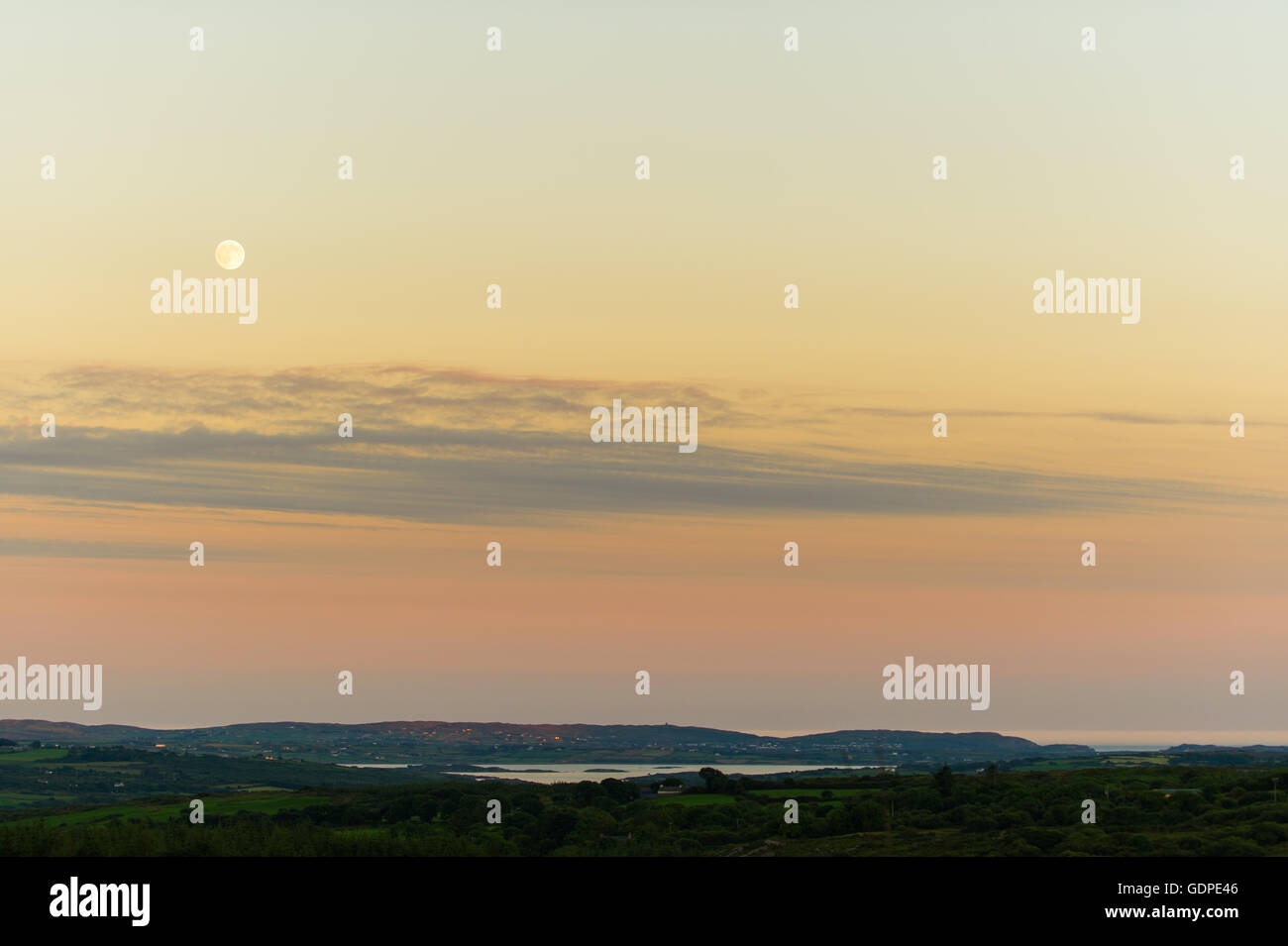 Lune au coucher du soleil sur Roaring Water Bay, West Cork, Irlande. Banque D'Images