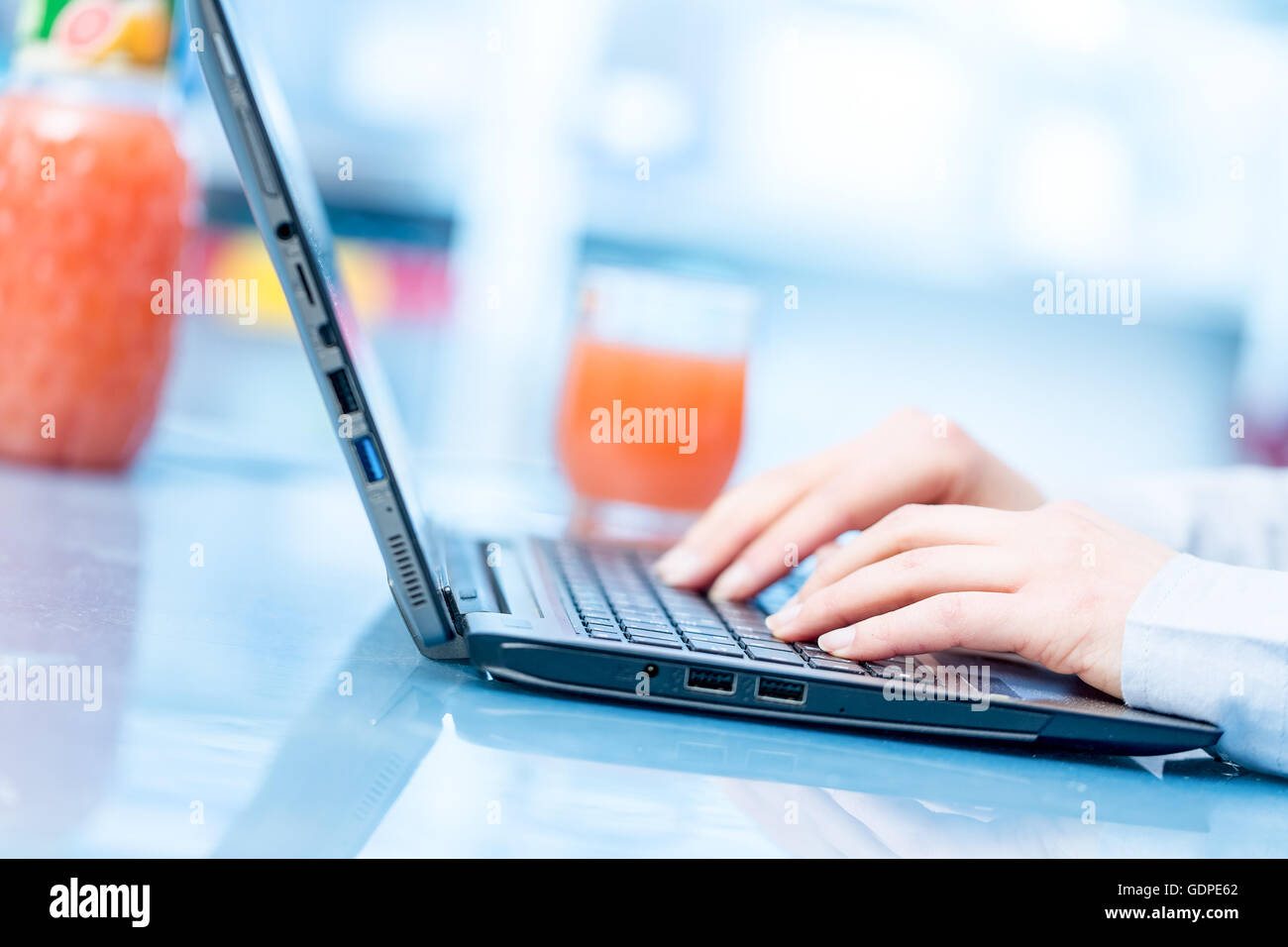 Les mains sur le clavier et le jus du matin matin Banque D'Images