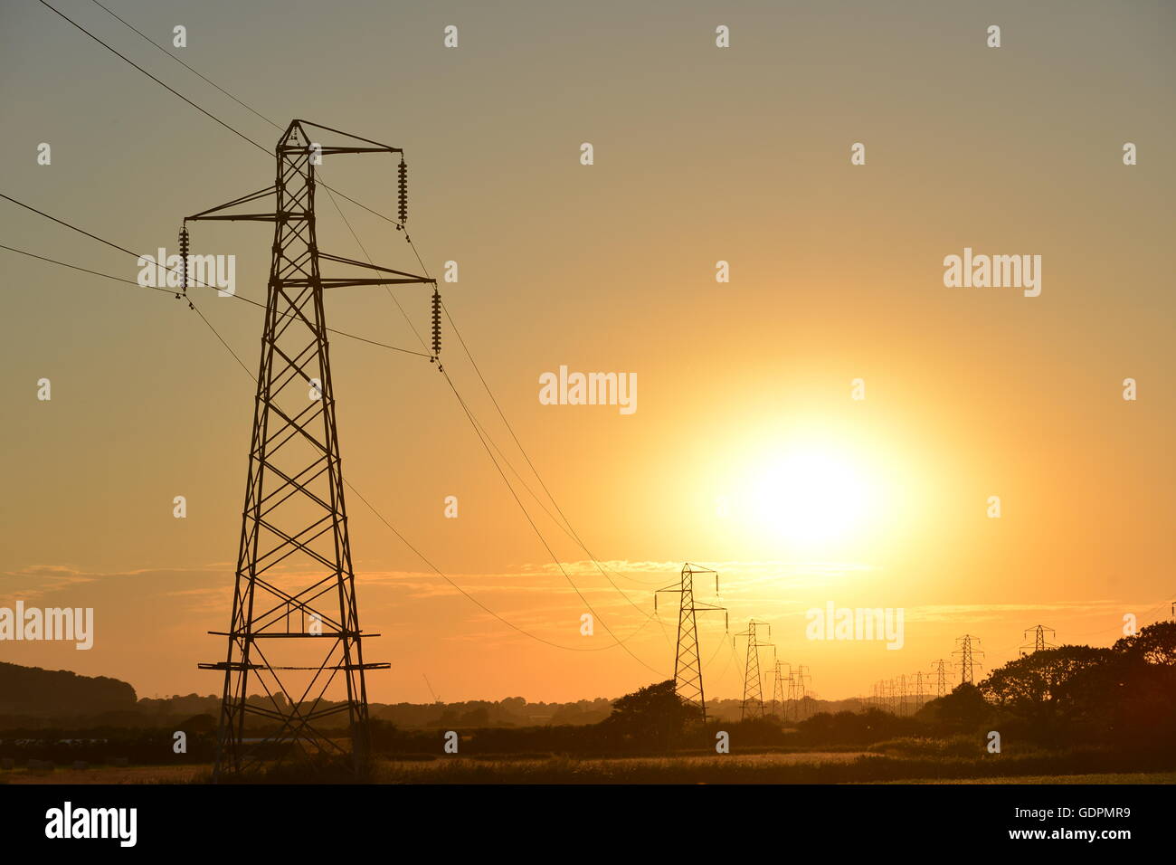 Soleil derrière les lignes de transport d'électricité Banque D'Images