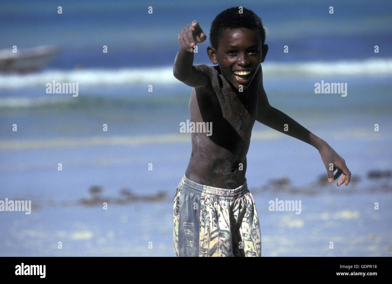 Ein Junge une einem Strand auf der Insel Mahé auf den Seychellen 151 mit dem Meer des Indische Ozean. Banque D'Images