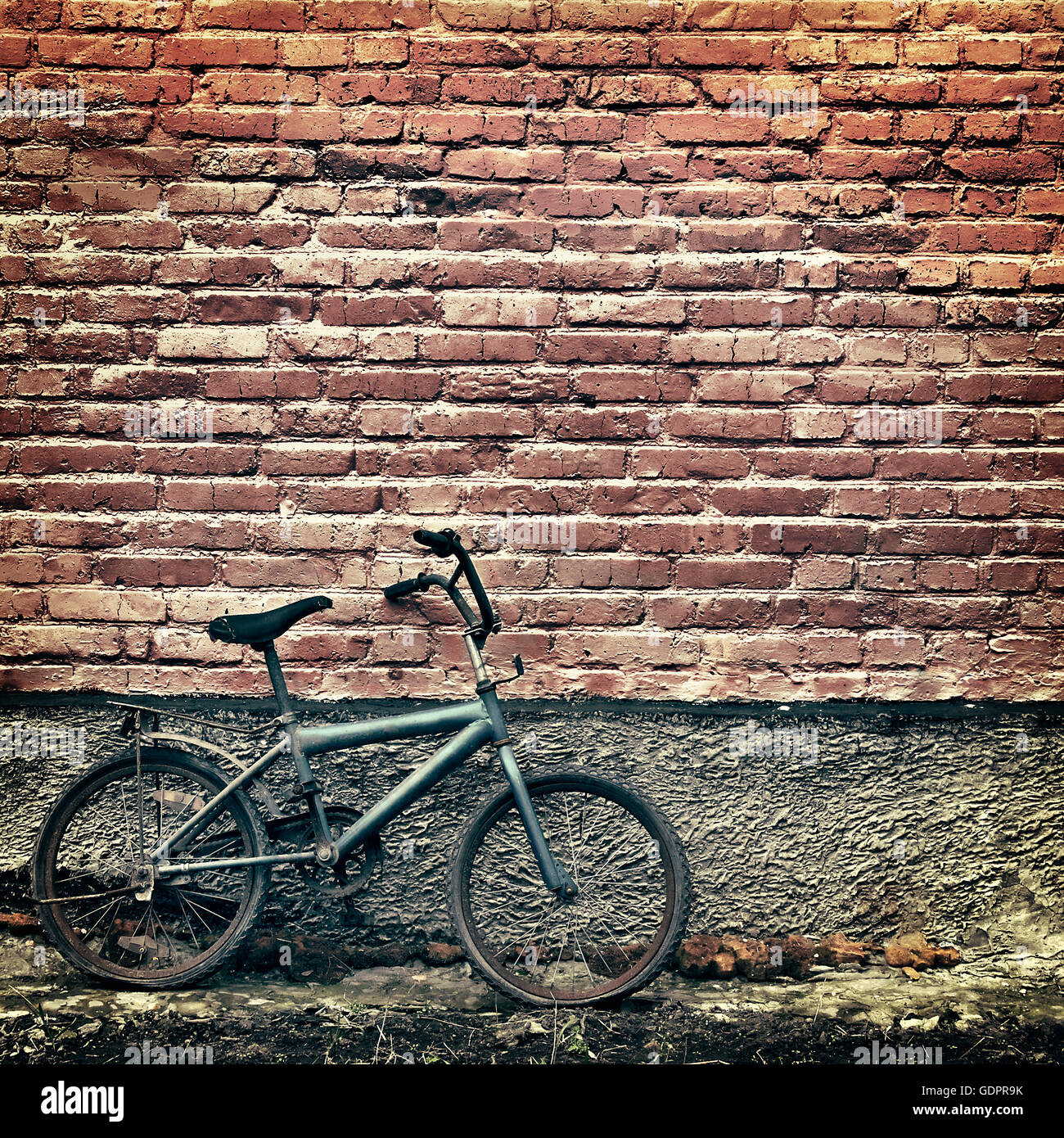 Old rusty vintage bicycle appuyé contre un mur de briques Banque D'Images