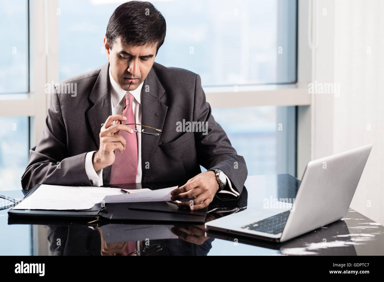 La haute direction indienne dans son bureau gratte-ciel, la lecture des contrats commerciaux Banque D'Images
