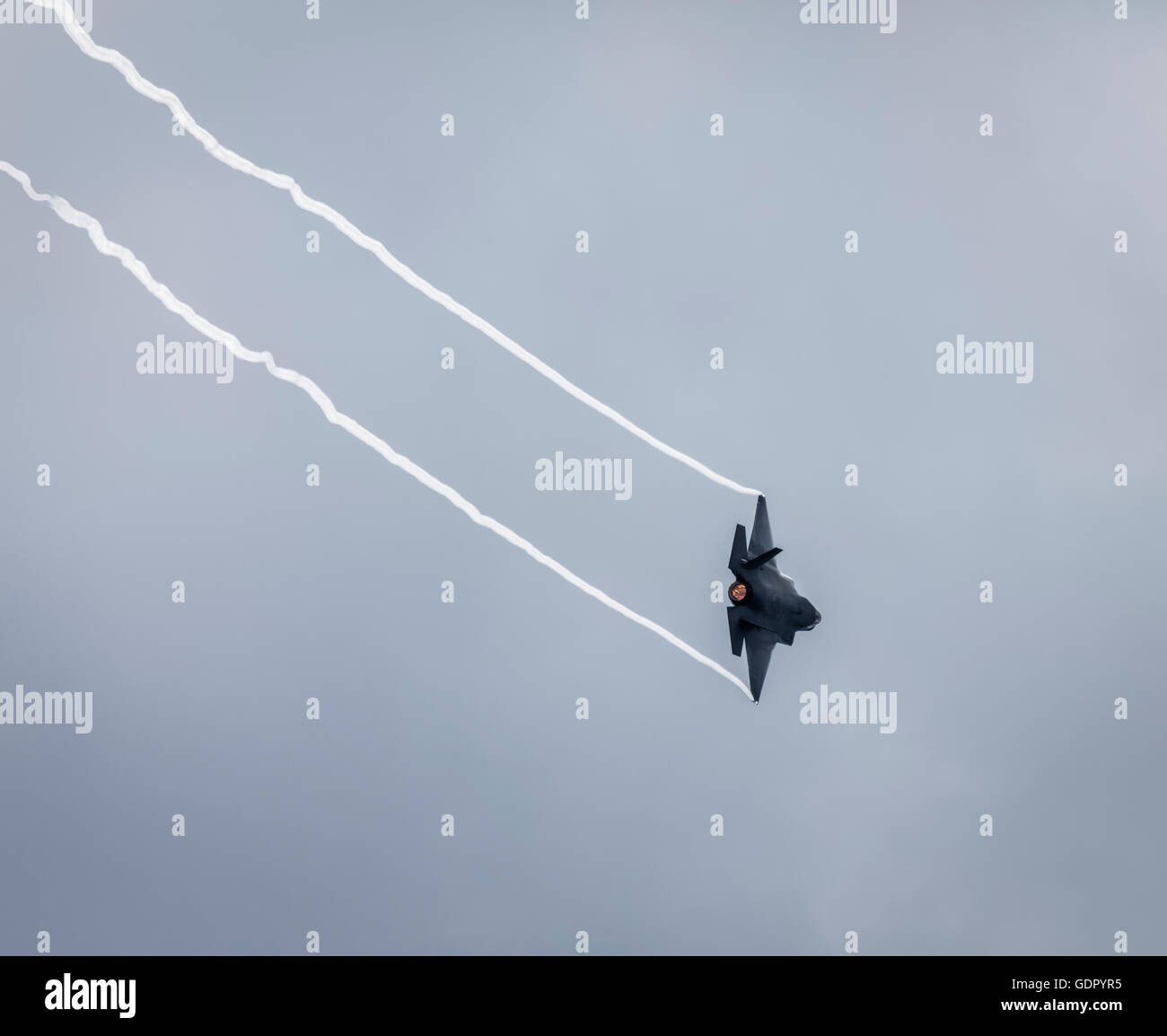 F-32B avion de chasse dans le ciel avec des traces de fumée de l'extrémité de chaque aile de l'avion et afterburn montrant sur le moteurs. Banque D'Images