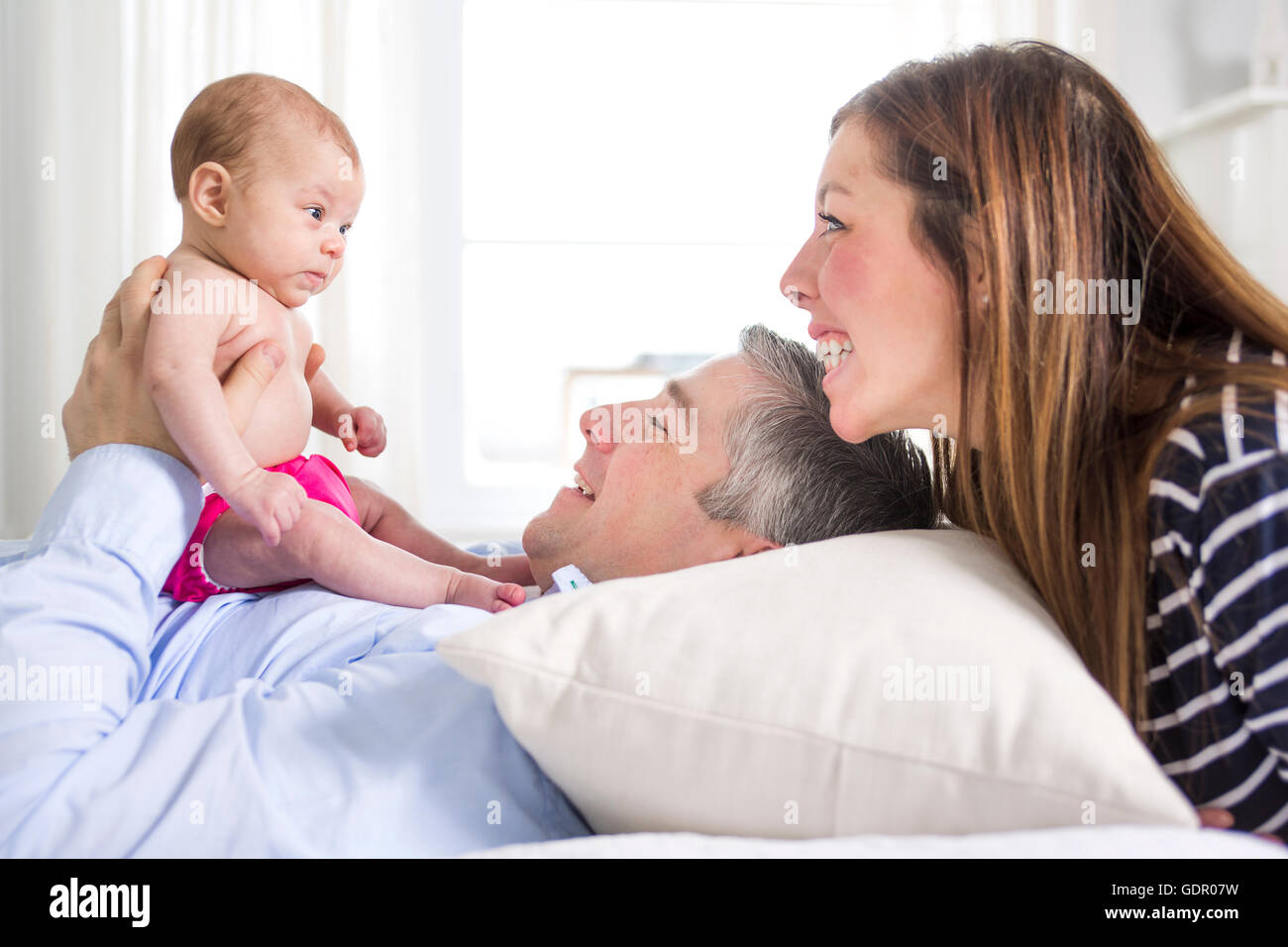 Les parents de câliner bébé nouveau-né dans le lit à la maison Banque D'Images