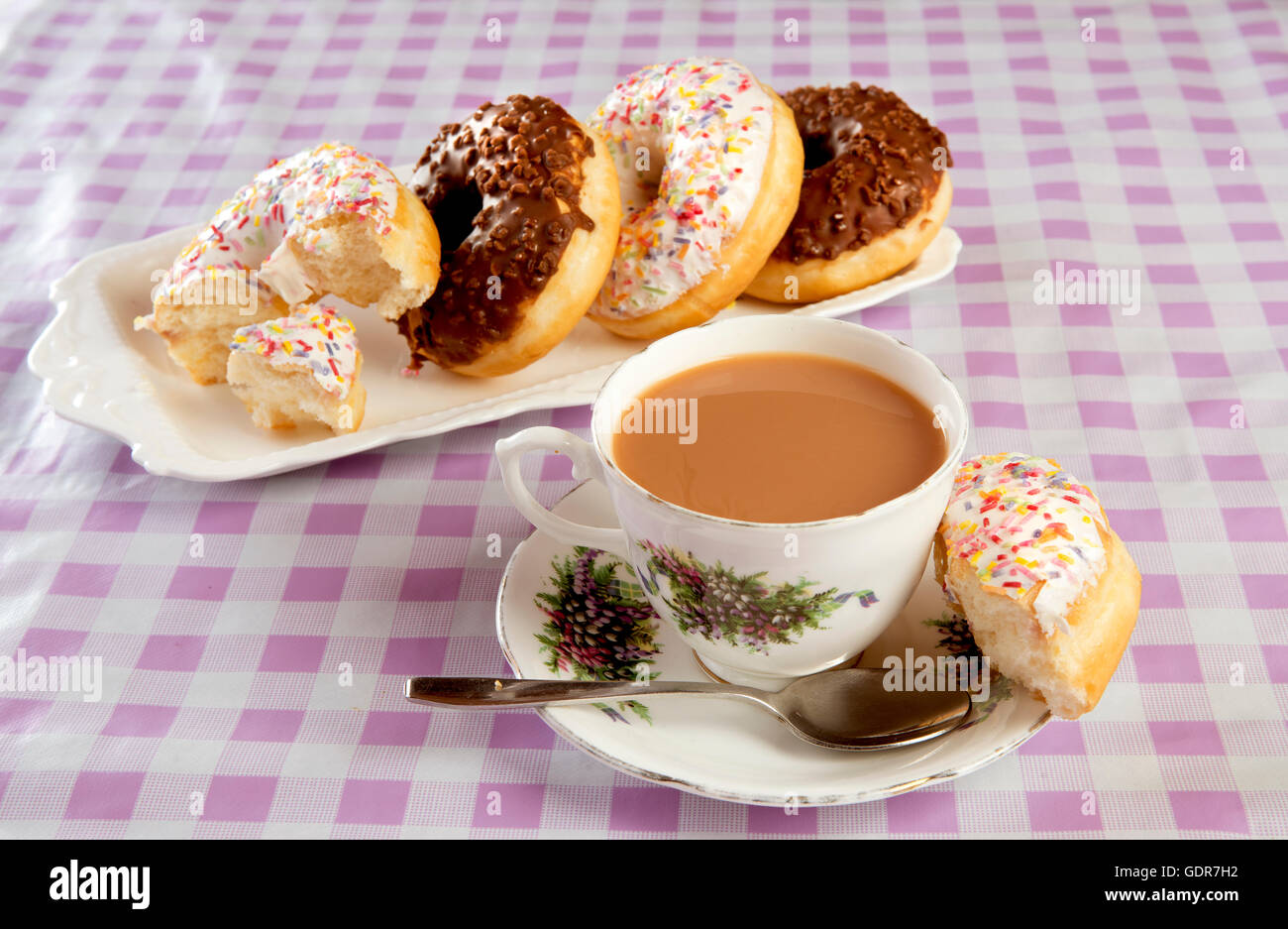 Une sélection de délicieux donuts et une tasse de thé Banque D'Images