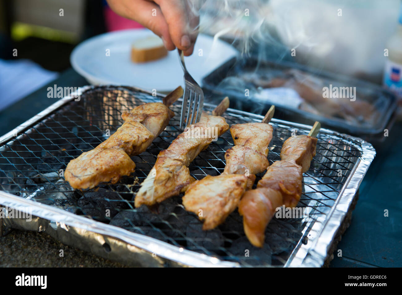 La viande de poulet savoureuse sur un feu de charbon de barbecue avec de la fumée Banque D'Images
