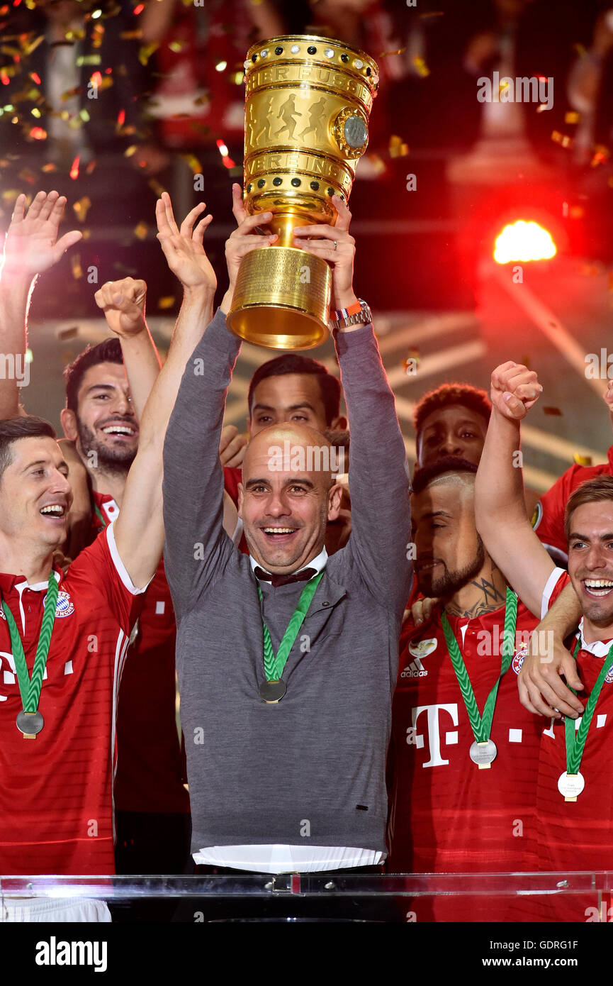 L'entraîneur Josep Guardiola Pep le DFB de levage dans l'air, encourageant après avoir remporté la finale de la Coupe de football avec des joueurs de football Bayern Banque D'Images