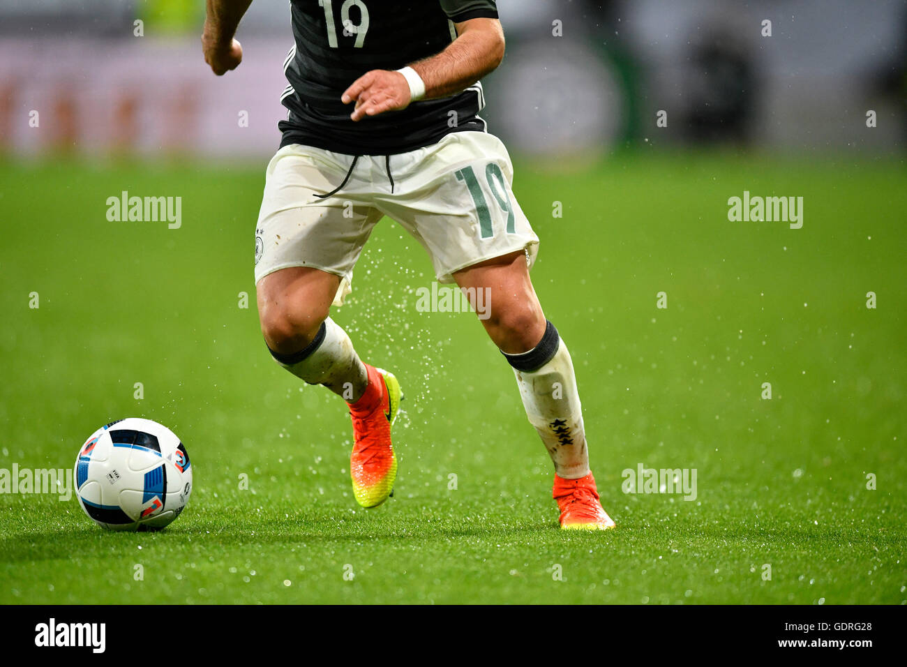 Détail, les jambes de Mario Goetze, joueur de football allemand, jouer la balle lorsqu'il pleut, WWK Arena, Augsbourg, Bavière, Allemagne Banque D'Images