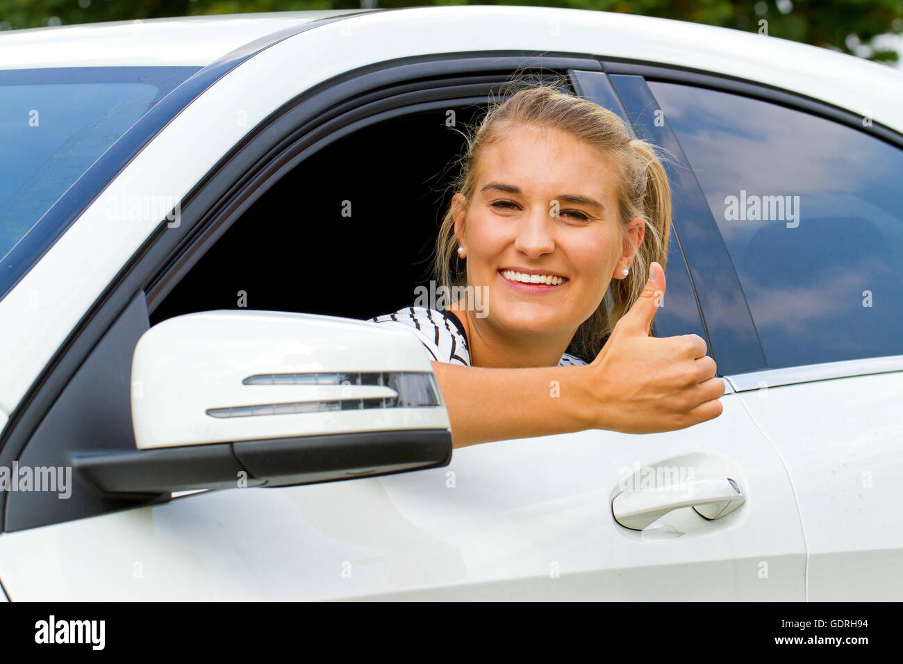 Happy girl dans une voiture avec thumb up Banque D'Images