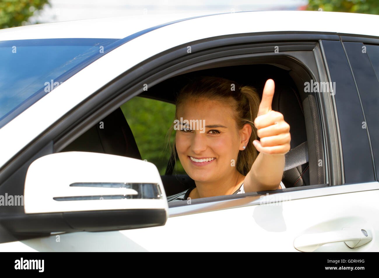Happy girl dans une voiture avec thumb up Banque D'Images